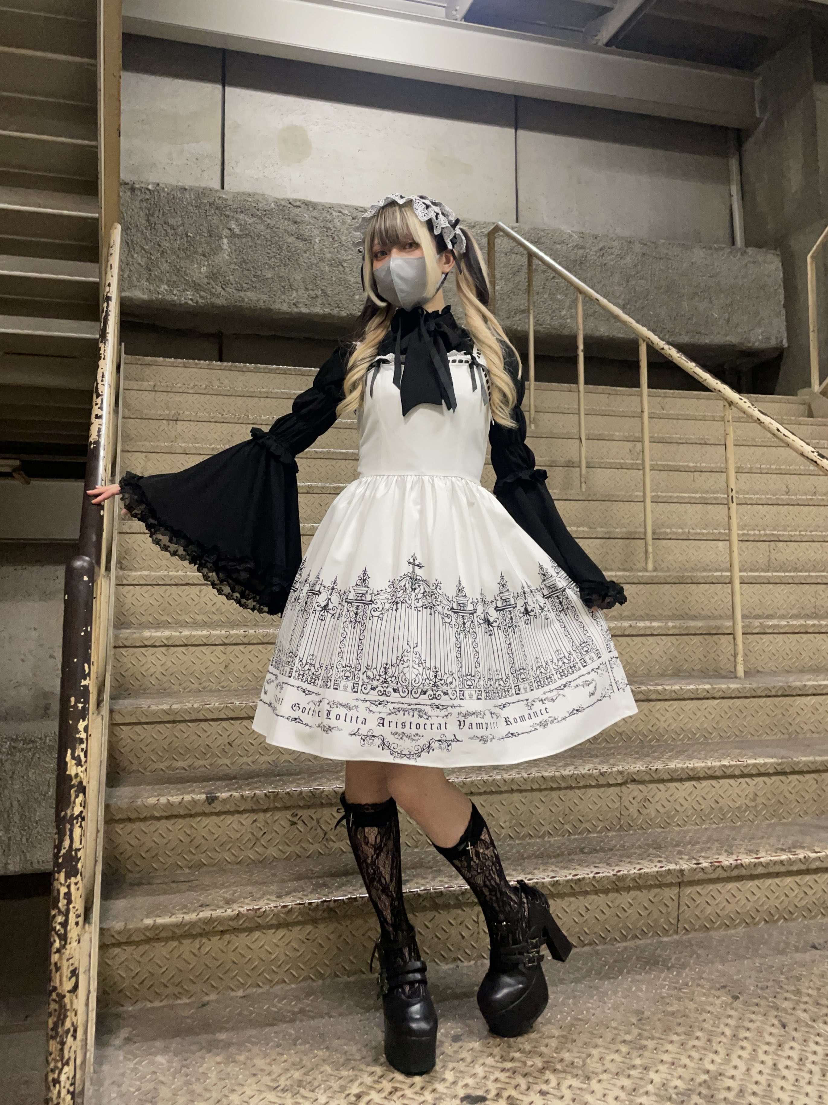 Satsuki from the Atelier Pierrot Harajuku store staff, wearing the Moi Meme Moitie Iron Gate JSK in white with a black petticoat. The black petticoat is not visible through the white fabric, demonstrating that the fabric is fully opaque.